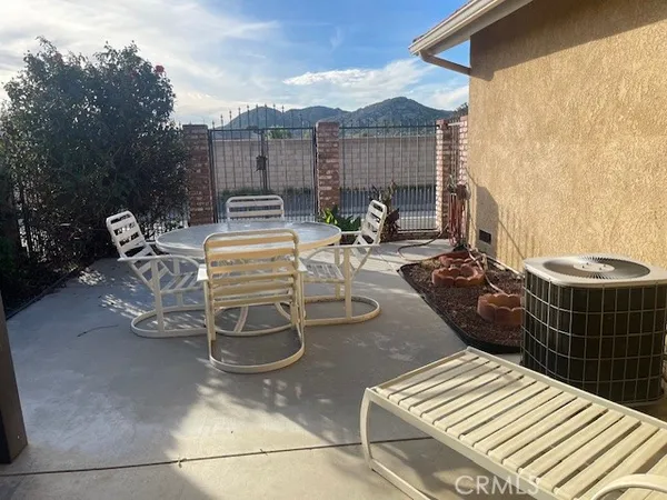 a view of a patio with table and chairs with wooden floor and fence
