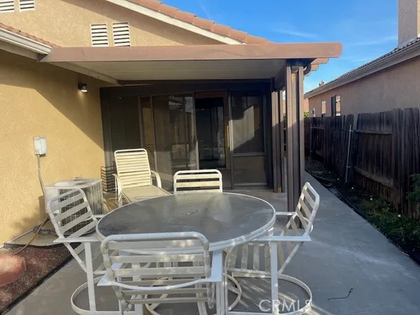 a view of a patio with table and chairs with wooden floor and fence