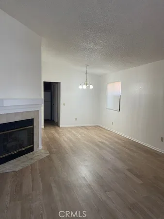 an empty room with windows and fireplace