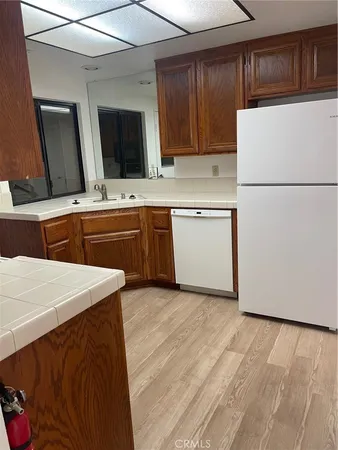 a kitchen with granite countertop white cabinets and refrigerator