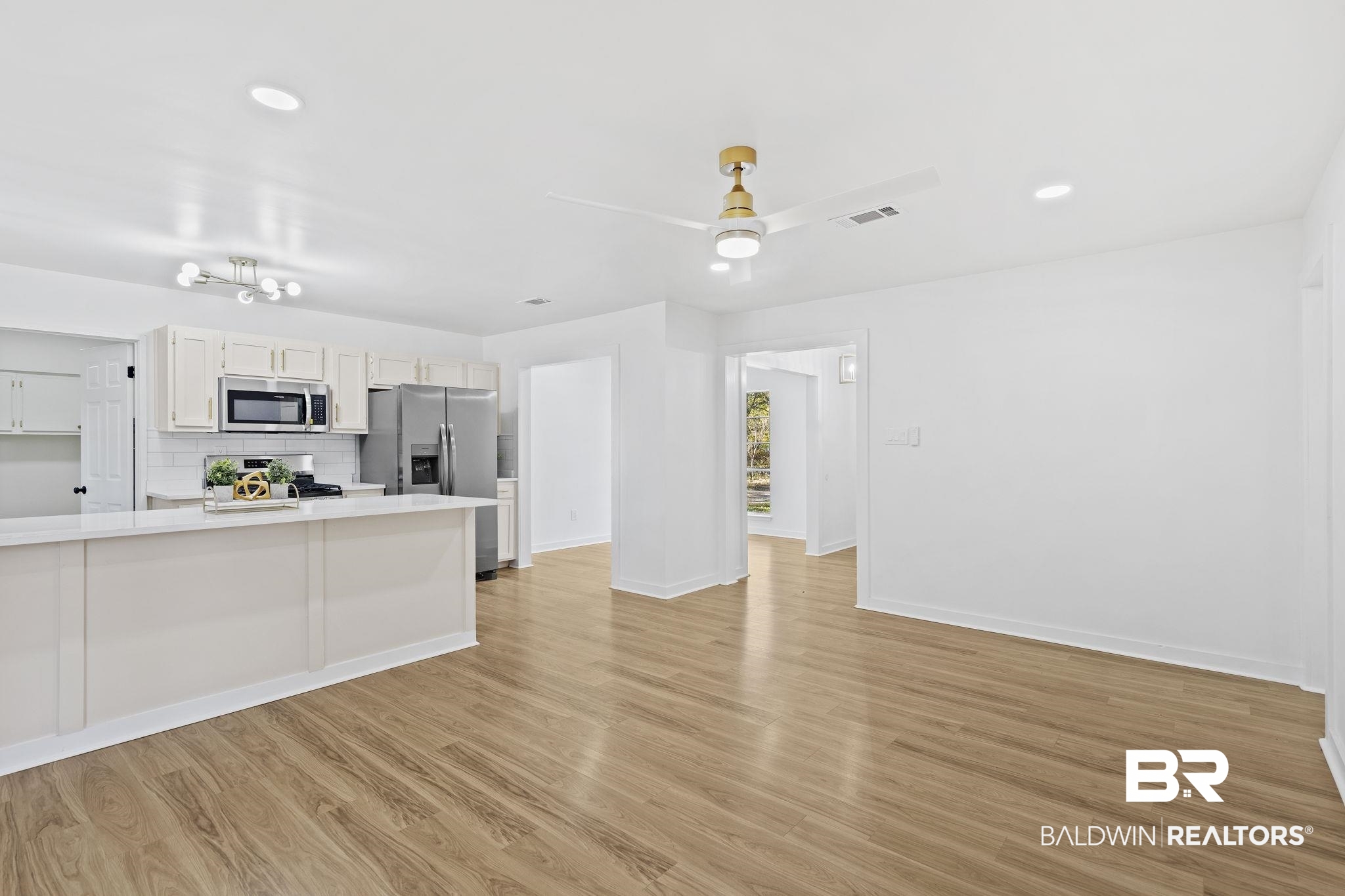 5398 Quail Run North Theodore, AL 36582 - Photo 24 of 46 Kitchen featuring tasteful backsplash, stainless steel appliances, ceiling fan, light hardwood / wood-style flooring, and white cabinets