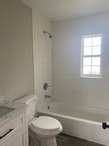 a white toilet and tub next to a window