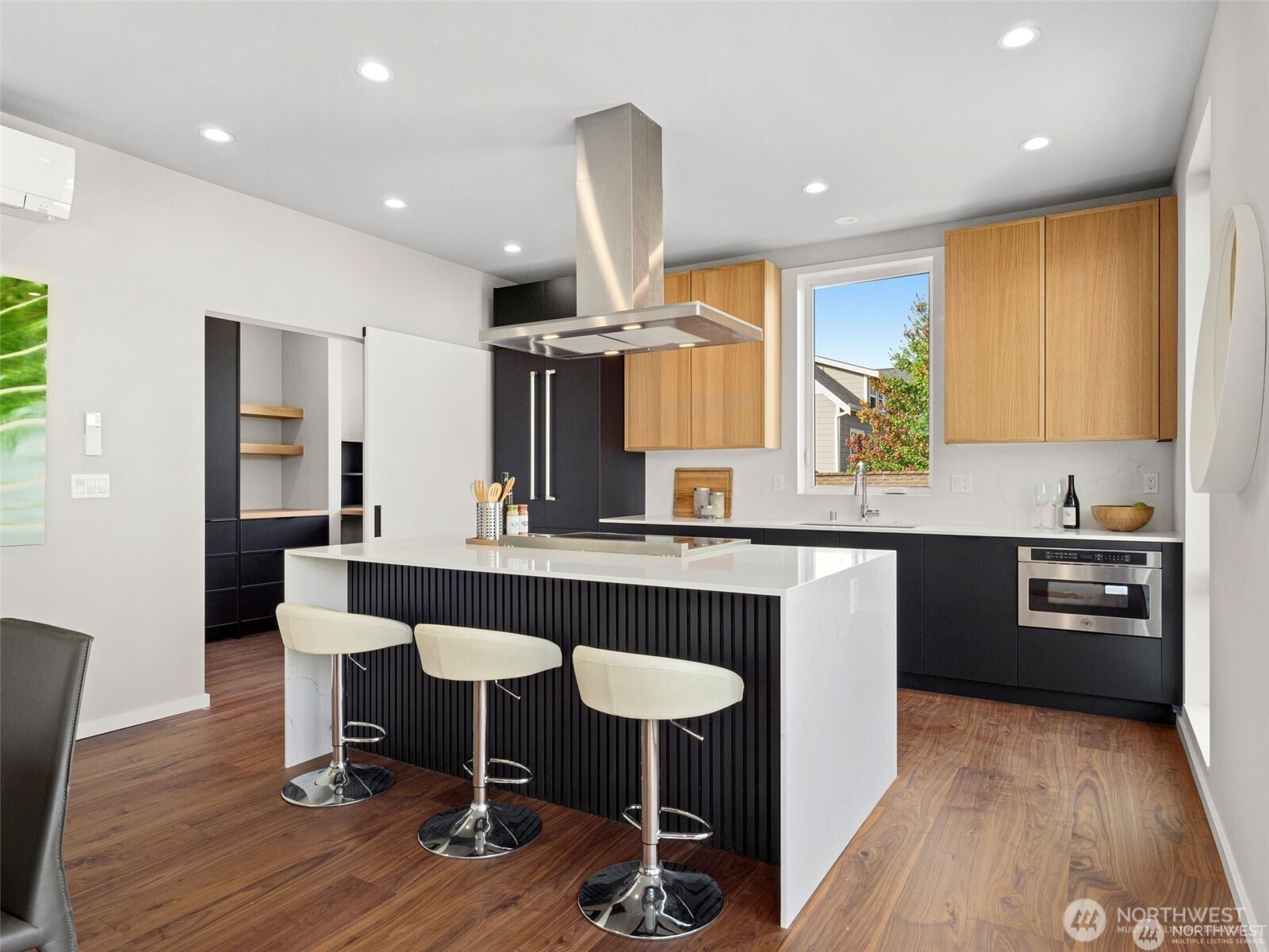 4464 Midvale Avenue North Seattle, WA 98103 - Photo 15 of 27 a kitchen with stainless steel appliances granite countertop a table chairs sink and wooden floor