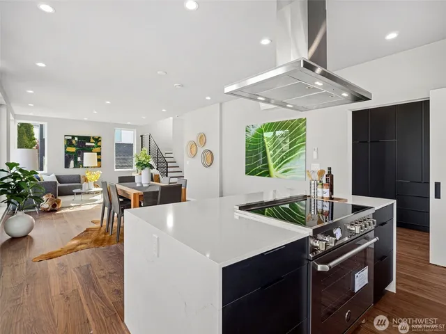 a kitchen with stainless steel appliances a table chairs and microwave
