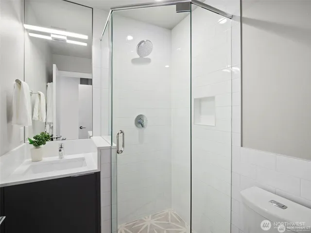 a bathroom with a sink a toilet and shower