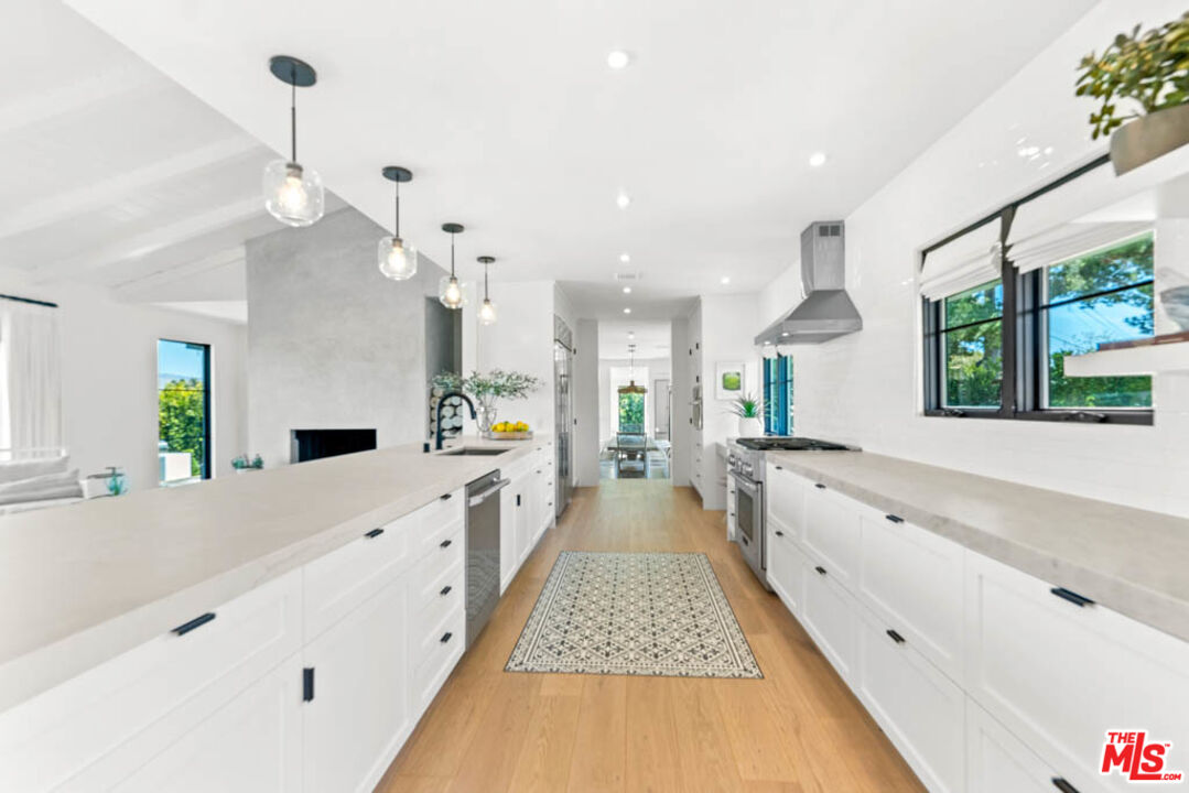 29351 Bluewater Road Malibu, CA 90265 - Photo 22 of 52 a large kitchen with kitchen island a large counter space a sink appliances and a large window