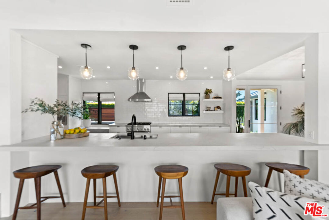 29351 Bluewater Road Malibu, CA 90265 - Photo 23 of 52 a kitchen with a table chairs stove and wooden floor