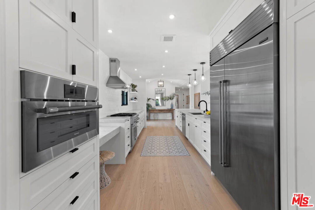 29351 Bluewater Road Malibu, CA 90265 - Photo 25 of 52 a view of a kitchen with a sink and dishwasher a refrigerator with wooden floor