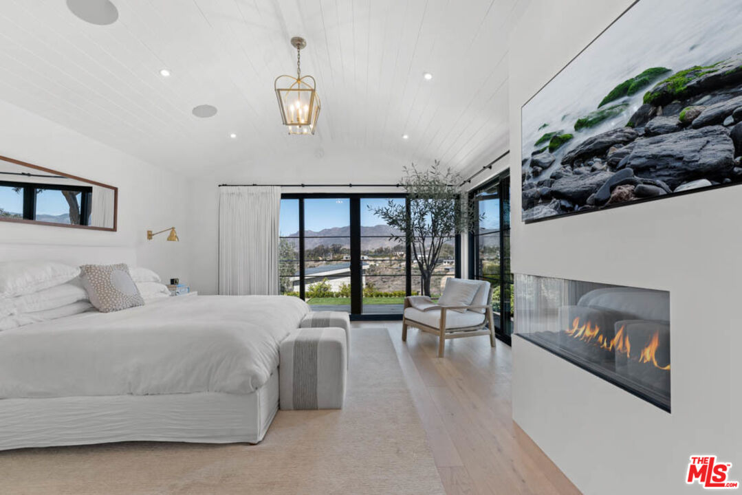 29351 Bluewater Road Malibu, CA 90265 - Photo 34 of 52 a bedroom with a balcony a bed and a fireplace