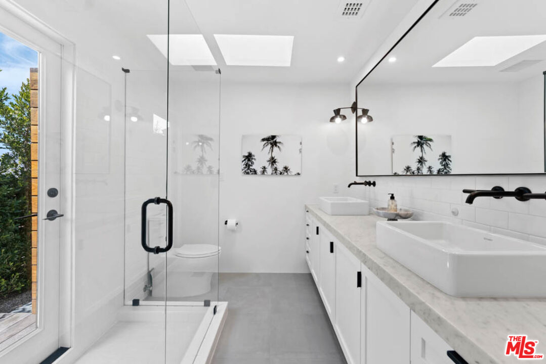 29351 Bluewater Road Malibu, CA 90265 - Photo 39 of 52 a bathroom with a double vanity sink mirror and shower