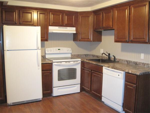 23 F Spencer Road, Unit 16 Boxborough, MA 01719 - Photo 1 of 1 a kitchen with a white stove top oven and refrigerator with wooden floor