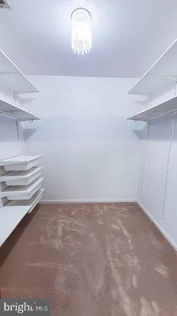 an empty room with windows and ceiling fan