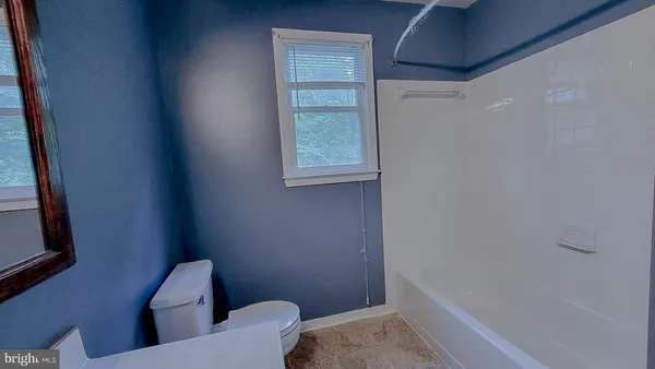 an empty room with windows and ceiling fan view