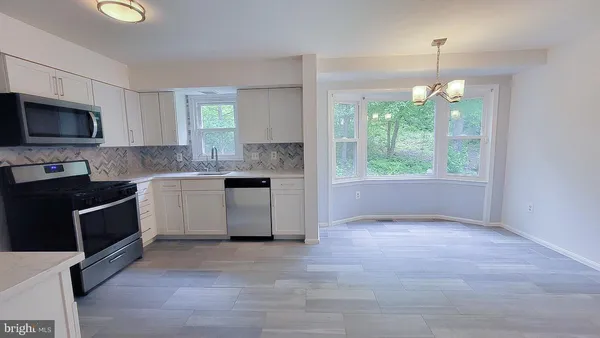 a kitchen with a stove a sink and a microwave