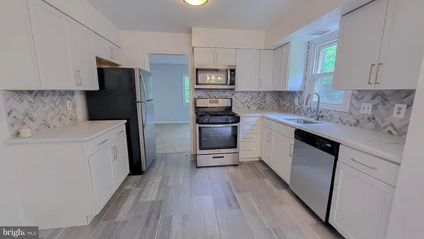 a kitchen with stainless steel appliances a refrigerator stove and sink