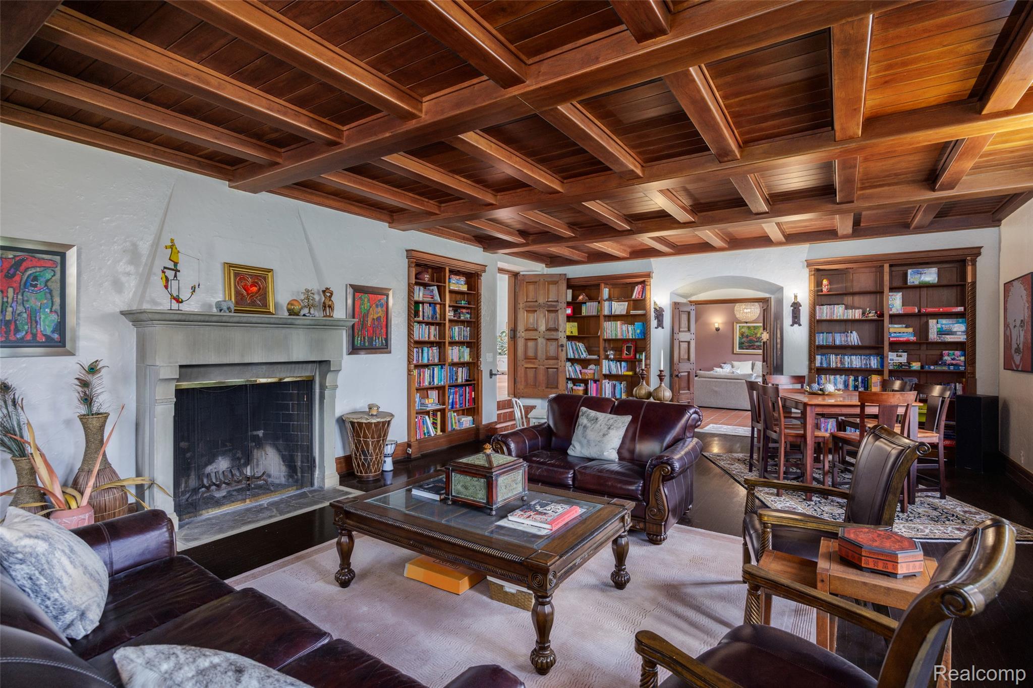189 Cloverly Road Grosse Pointe, MI 48236 - Photo 17 of 93 Where craftsmanship meets comfort. Anchored by a hand-carved limestone fireplace and crowned by an exquisitely crafted coffered wood ceiling, the library is designed for life’s quieter moments. Built-in bookcases, rich hardwood floors, and inviting seating create a warm, welcoming retreat for reading, conversation, and evenings spent with family and friends.