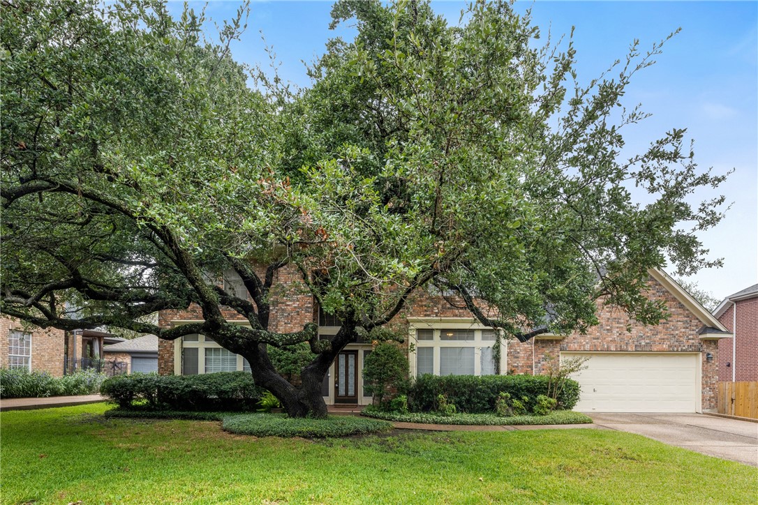 a front view of a house with a garden and trees