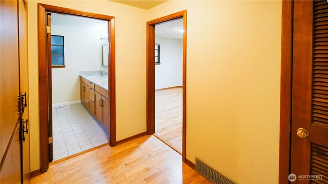 a view of a hallway with wooden floor and staircase