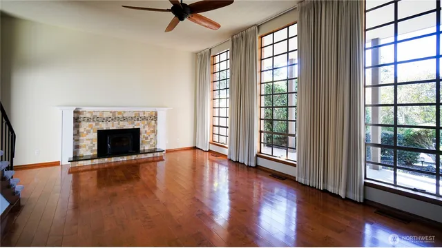 wooden floor fireplace and windows in an empty room