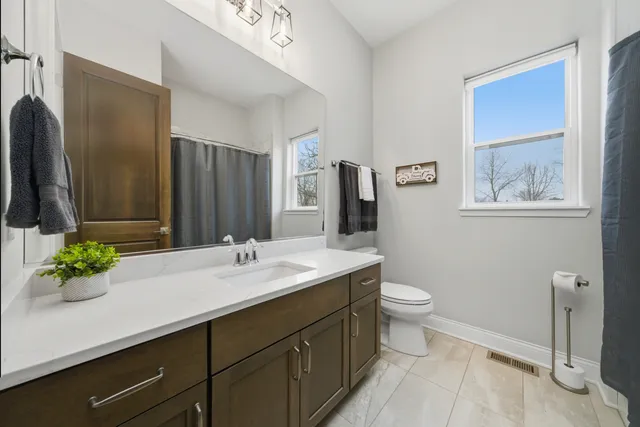 a bathroom with a sink toilet a mirror and shower