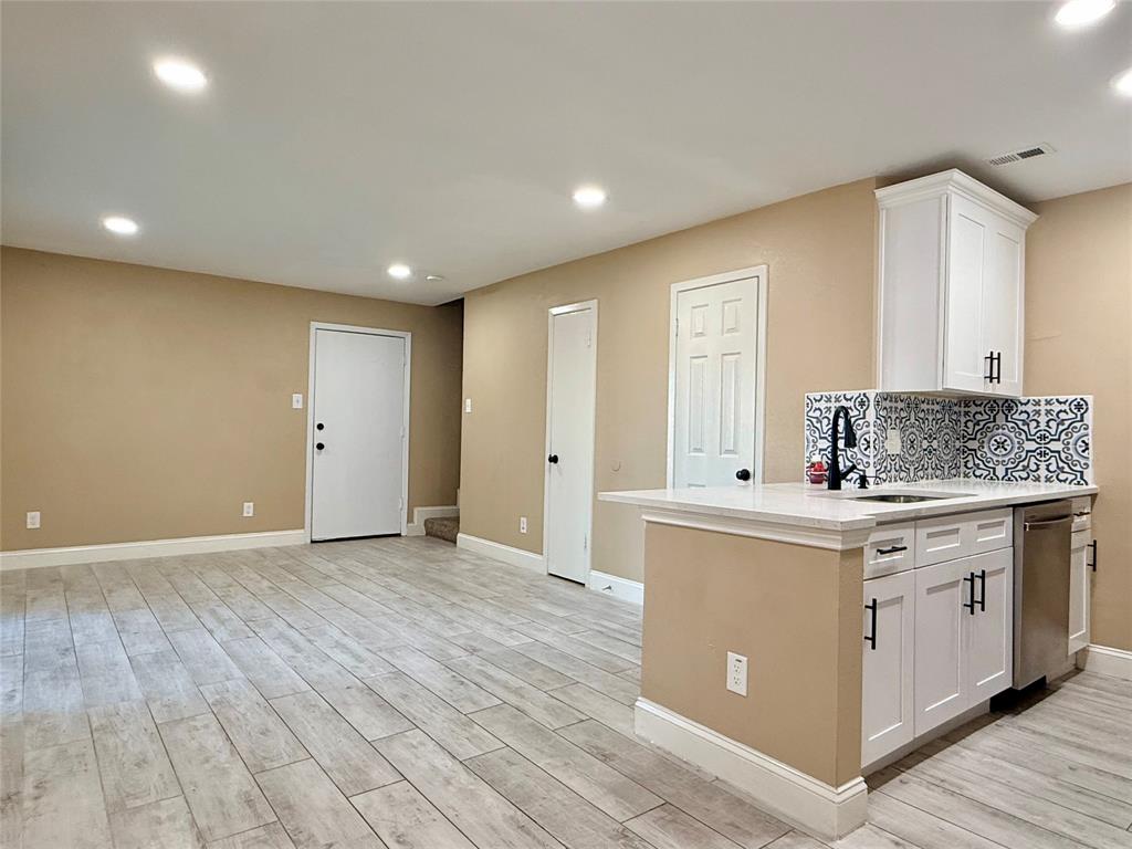 12802 Midway Road, Unit 2015 Dallas, TX 75244 - Photo 3 of 15 Kitchen featuring recessed lighting, a peninsula, white cabinets, wood tiled floors, and decorative backsplash
