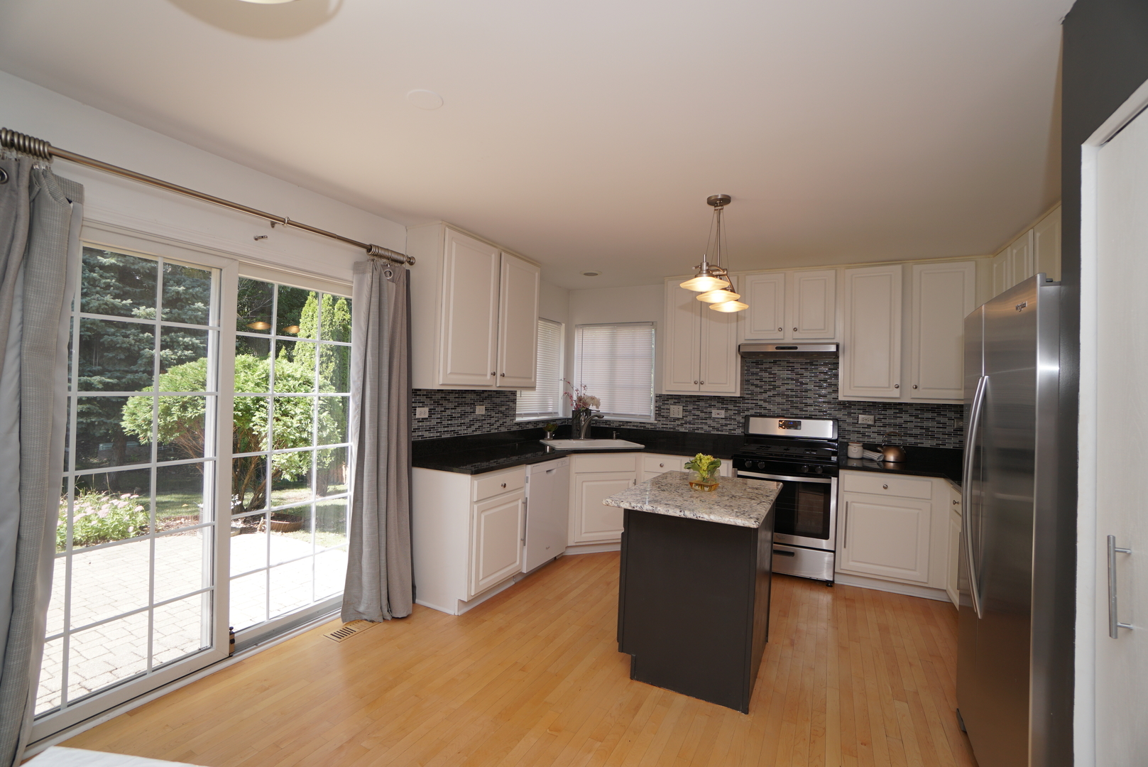 1910 Avalon Drive Wheeling, IL 60090 - Photo 6 of 36 a kitchen with stainless steel appliances granite countertop a stove a refrigerator a sink a microwave and island