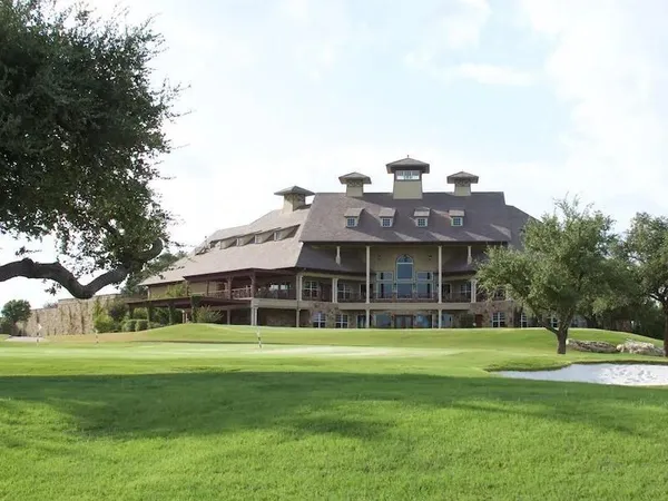 a view of a house with a big yard and large trees