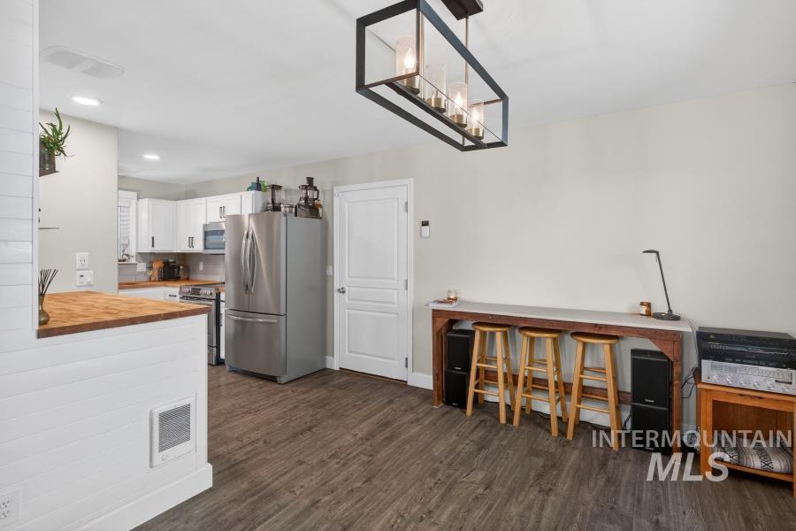 1342 Bristol Road Moscow, ID 83843 - Photo 13 of 26 Kitchen featuring wood counters, stainless steel appliances, white cabinetry, dark wood finished floors, and a chandelier