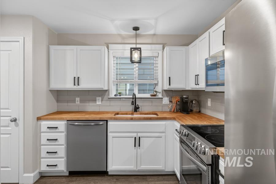 1342 Bristol Road Moscow, ID 83843 - Photo 8 of 26 Kitchen featuring stainless steel appliances, wooden counters, white cabinets, and pendant lighting