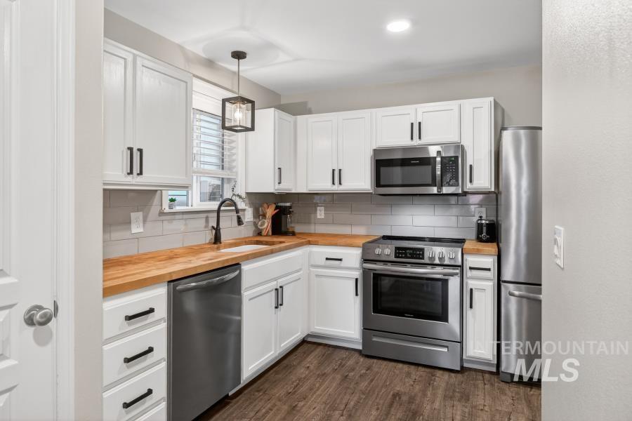 1342 Bristol Road Moscow, ID 83843 - Photo 9 of 26 Kitchen with butcher block counters, stainless steel appliances, white cabinets, and hanging light fixtures