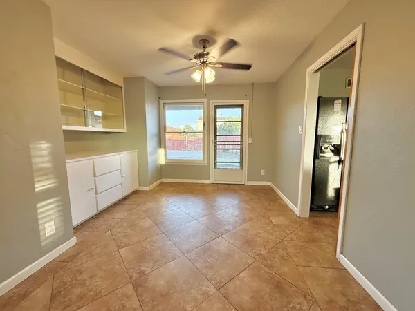 a view of an empty room with window and cabinet