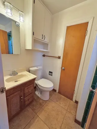 a bathroom with a toilet sink and mirror