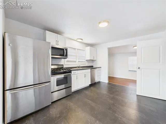 a kitchen with stainless steel appliances a refrigerator sink and microwave