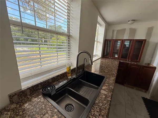 a close view of a sink a window and stainless steel appliances