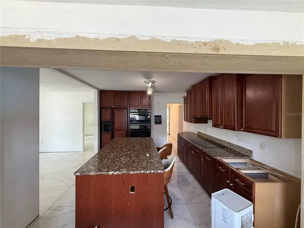 a kitchen with kitchen island sink refrigerator and stove