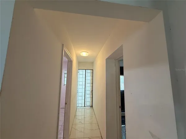 a view of hallway with closet and a window