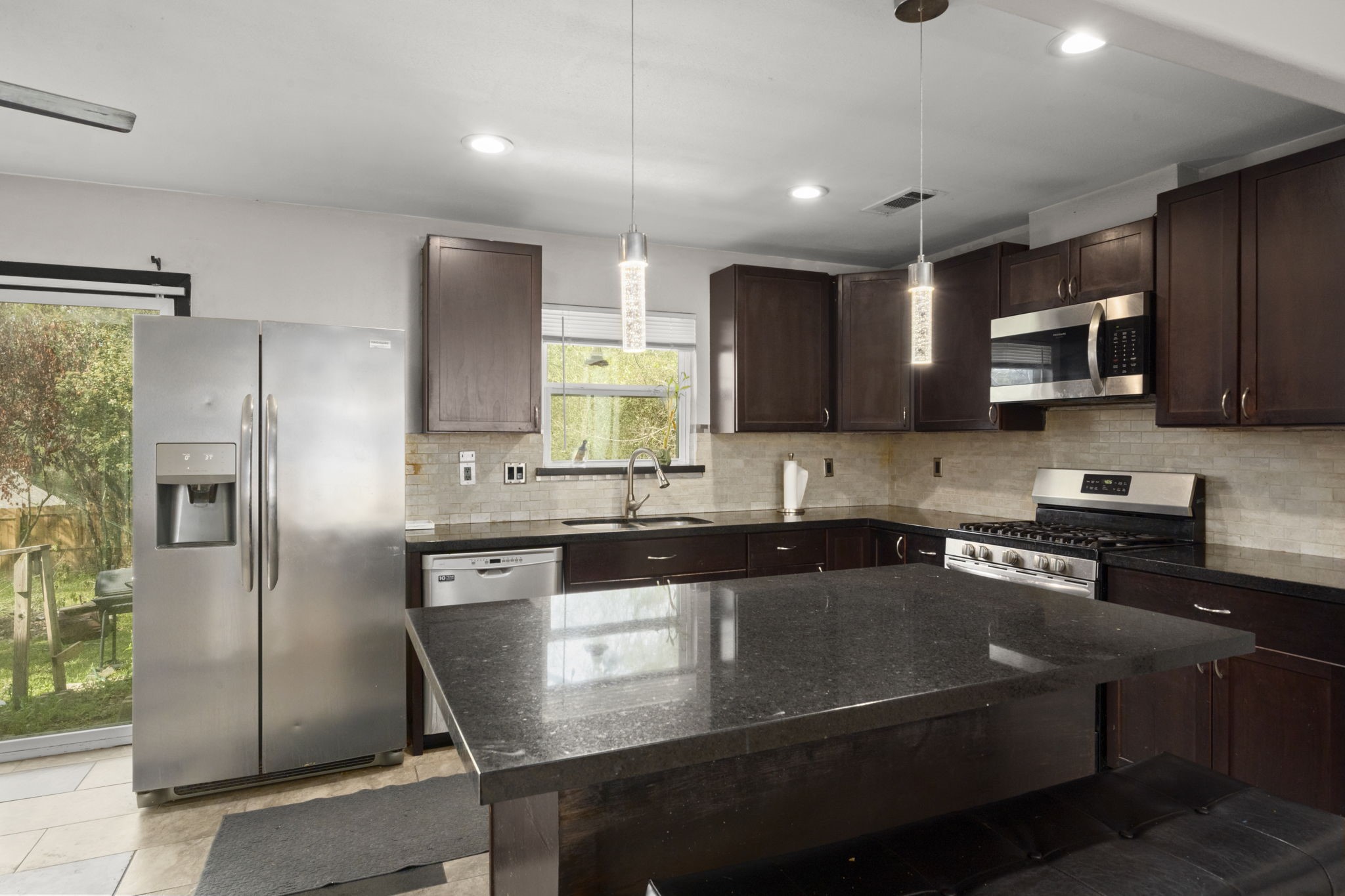 3414 Rustling Pines Street Spring, TX 77380 - Photo 8 of 26 a kitchen with stainless steel appliances granite countertop a refrigerator a stove a sink a microwave and a refrigerator