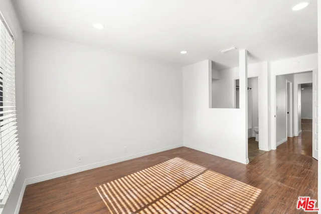 a view of a room with wooden floor and white walls