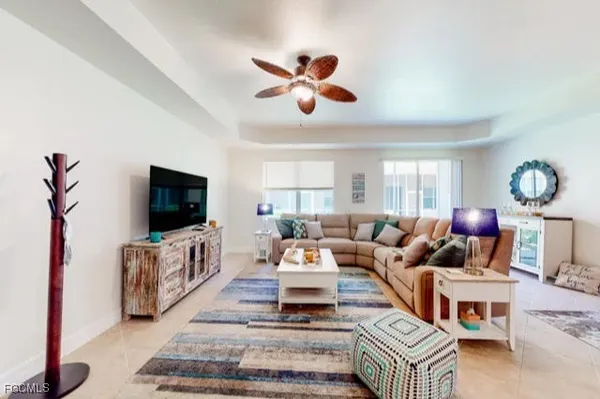 a living room with furniture a flat screen tv and a window