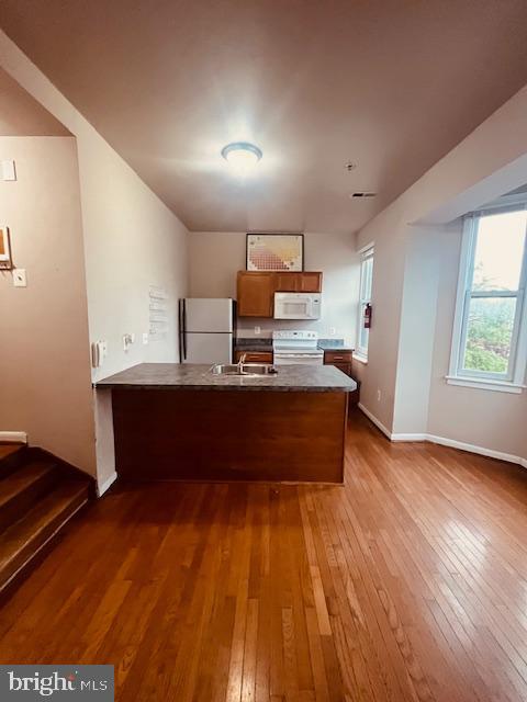 3344 East Baltimore Street, Unit 2 Baltimore, MD 21224 - Photo 4 of 12 a kitchen with stainless steel appliances kitchen island wooden floors and granite counter tops