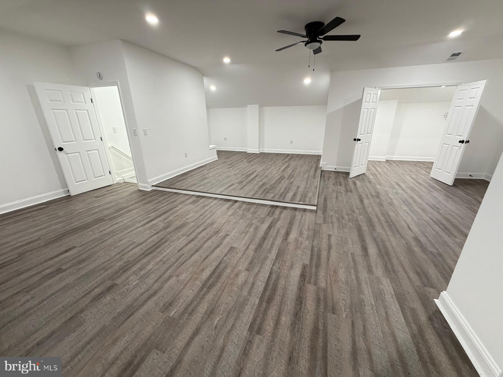 959 Golf Course Road Martinsburg, WV 25404 - Photo 28 of 35 an empty room with wooden floor ceiling fan and kitchen view