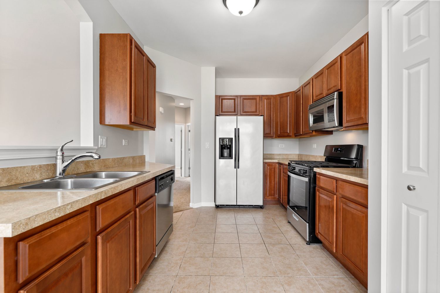 311 Timber Ridge Court Joliet, IL 60431 - Photo 9 of 24 a kitchen with stainless steel appliances granite countertop a refrigerator stove and sink