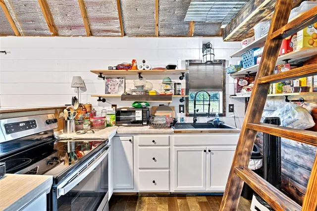 a kitchen with stainless steel appliances a stove a sink and cabinets
