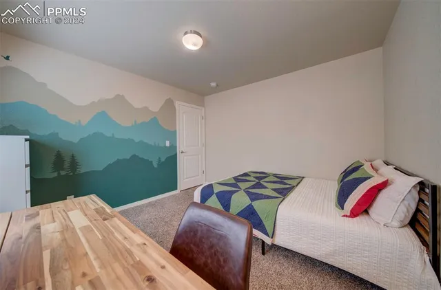 a bedroom with a bed and a painting on the wall