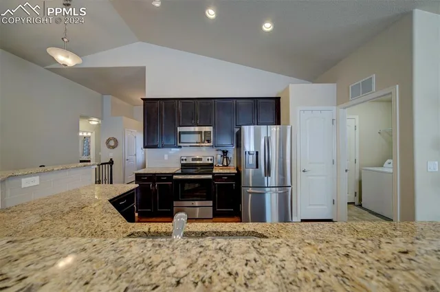 a kitchen with kitchen island a counter top space cabinets and stainless steel appliances