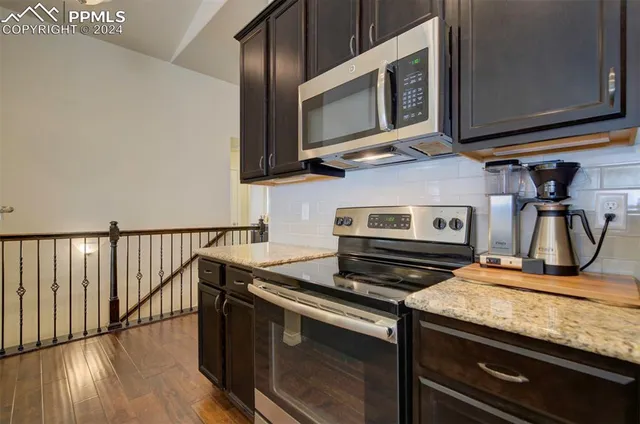 a kitchen with stainless steel appliances granite countertop a stove and a microwave