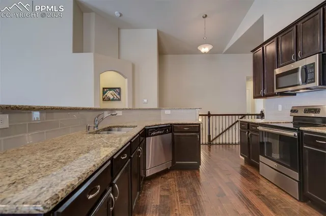 a kitchen with granite countertop stainless steel appliances and wooden cabinets