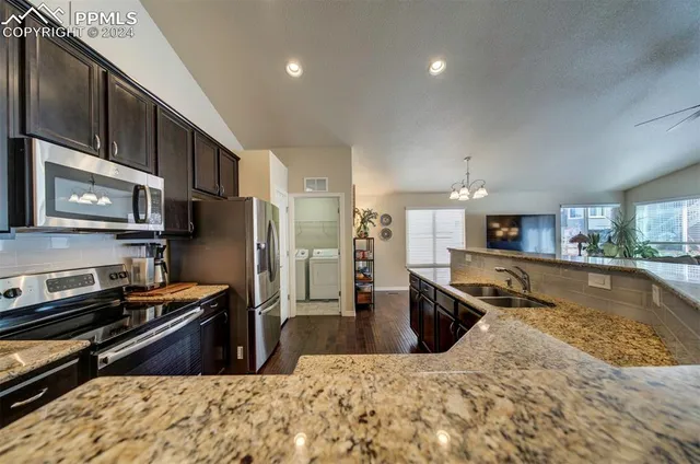 a kitchen with stainless steel appliances granite countertop a refrigerator stove and oven