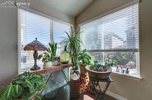 a vase of flowers sitting on a table with wooden floor