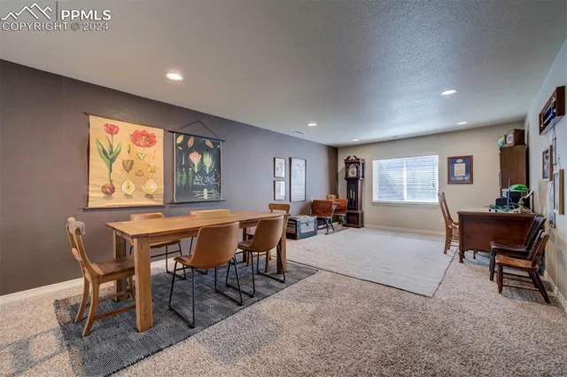 a living room with furniture a large window and kitchen view